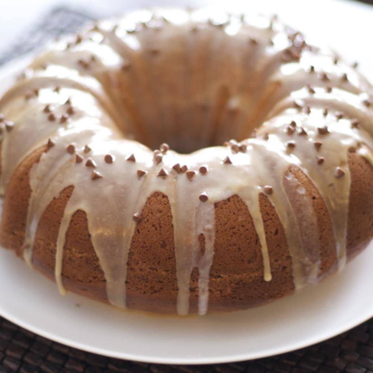 Coffee streusel bundt cake on a white plate with drizzle.